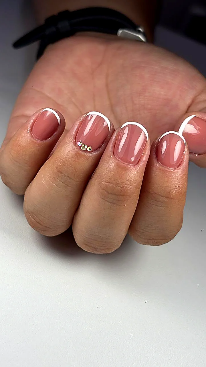 Manicura francesa nude con cristales sobre uñas almendra